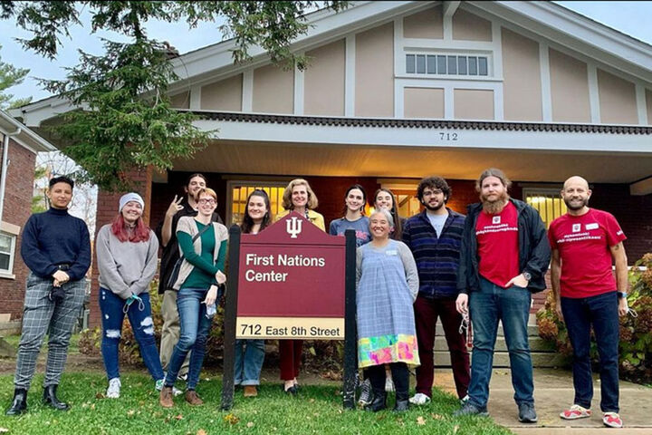 A group gathers in front of the First Nations Center with President Whitten.